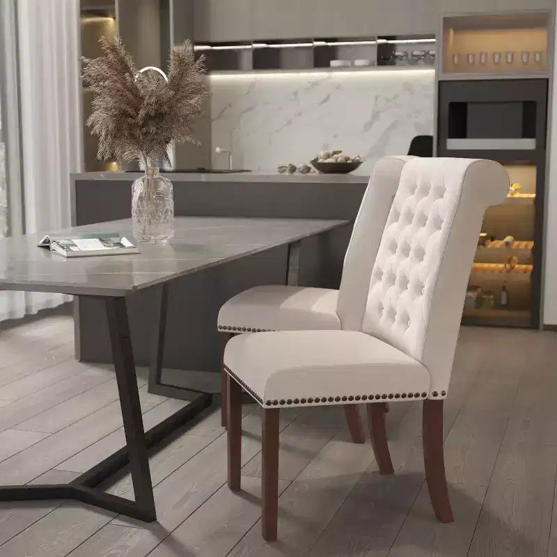 Silla de comedor Parson tapizada con respaldo enrollado, ribete de tachuelas y estructura con acabado y deslizadores de plástico para el suelo