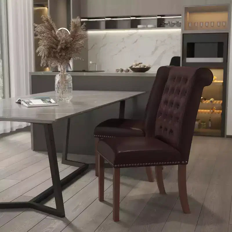 Silla de comedor Parson tapizada con respaldo enrollado, ribete de tachuelas y estructura con acabado y deslizadores de plástico para el suelo