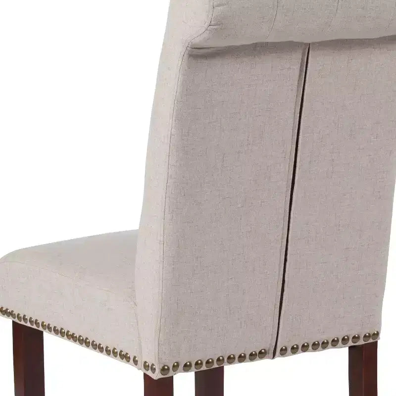 Silla de comedor Parson tapizada con respaldo enrollado, ribete de tachuelas y estructura con acabado y deslizadores de plástico para el suelo